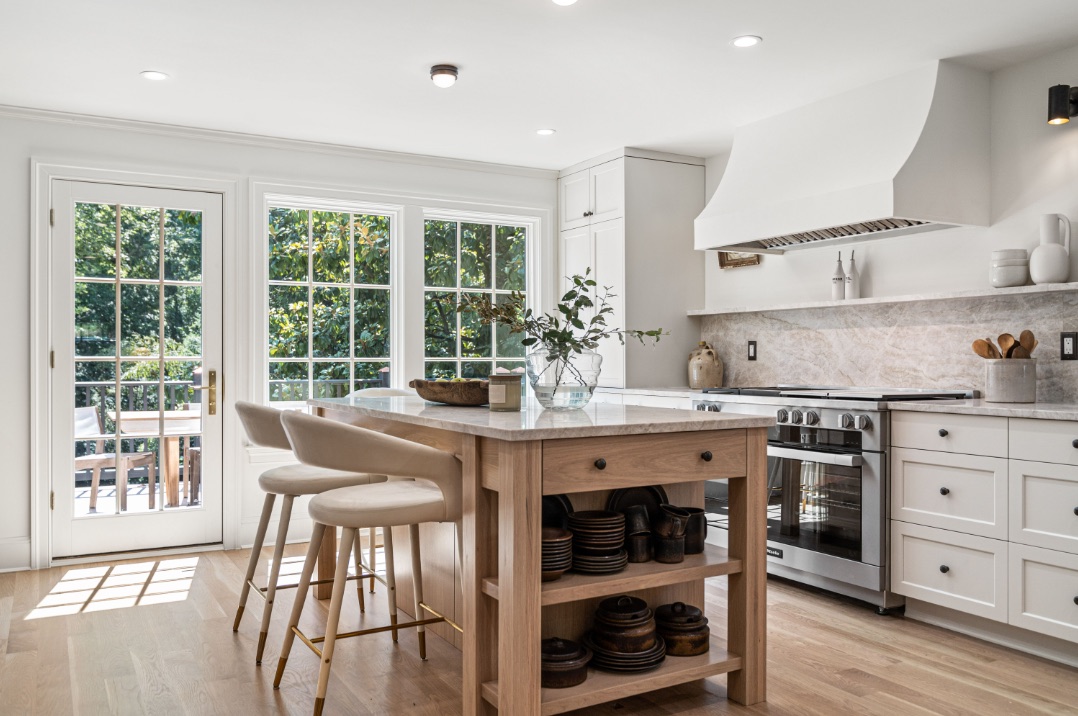 A Scribe kitchen with a natural wood island, stone surfaces, and sunlit French doors